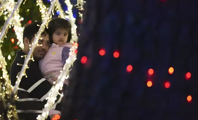 A family looks at the Lights of Joy display Monday, Dec. 16, 2024, in Kennesaw, Ga. (AP Photo/Brynn Anderson)