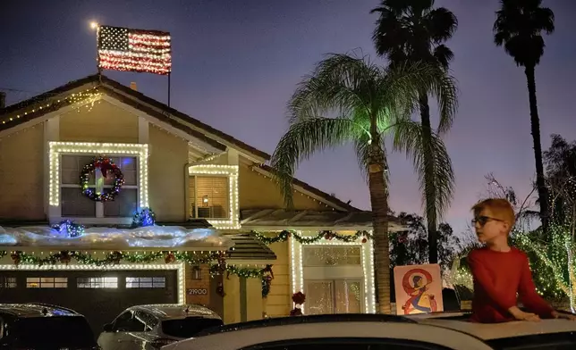 Local residents drive through the Wakefield Winter Wonderland neighborhood decorated with Christmas lights in Santa Clarita, Calif. on Dec. 17, 2024. (AP Photo/Richard Vogel)