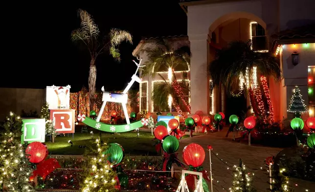 A giant rocking horse is displayed on the front lawn of a home decorated with holiday lights in a neighborhood in Mesa, Ariz., Thursday, Dec. 12, 2024, in Mesa, Ariz. (AP Photo/Ross Franklin)