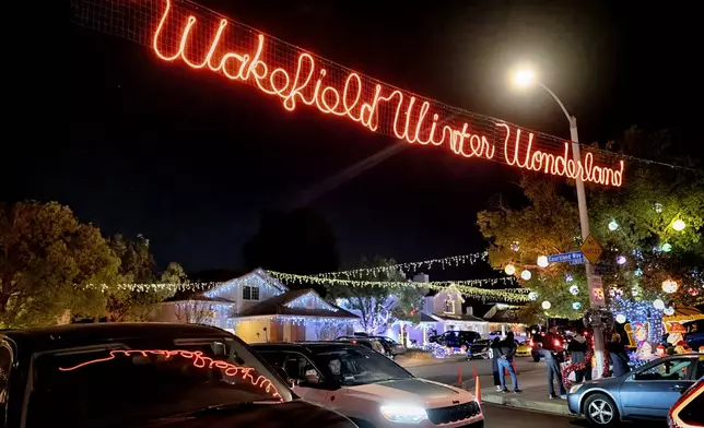 Local residents drive through the Wakefield Winter Wonderland neighborhood decorated with Christmas lights in Santa Clarita, Calif. on Dec. 17, 2024. (AP Photo/Richard Vogel)