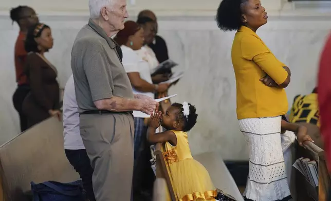 Phara Pierre, right, and her daughter attend Mass at St Raphael Catholic church in Springfield, Ohio, Sunday, Sept. 15, 2024. (AP Photo/Jessie Wardarski)