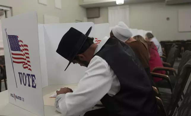 Members of the Amish community, Samuel Stoltzfus and his wife Lillian Stoltzfus, vote at a polling center at the Garden Spot Village retirement community in New Holland, Pa., Tuesday, Nov. 5, 2024. (AP Photo/Luis Andres Henao)