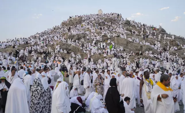 Muslim pilgrims gather at the top of the rocky hill known as the Mountain of Mercy, on the Plain of Arafat, during the annual Hajj pilgrimage, near the holy city of Mecca, Saudi Arabia, Saturday, June 15, 2024. (AP Photo/Rafiq Maqbool)