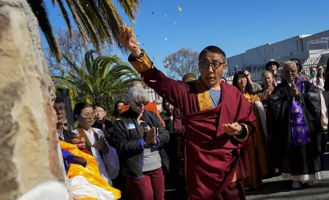 Khenpo Paljor, a Tibetan lama from Des Moines, Iowa, leads a prayer at the Birthplace of Antioch marker, Saturday, March 16, 2024, in Antioch, Calif. Participants of the event titled "May We Gather" placed traditional Tibetan scarves on the marker as they prayed for peace and harmony. (AP Photo/Godofredo A. Vasquez)