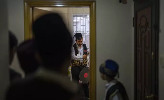 "Ramazan davulcusu" or Ramadan drummer Muzaffer Kara gets dressed with a traditional attire at his house, in Istanbul, Thursday, March 28, 2024. From the Ottoman era, drummers dressed up with traditional attire play drums in their neighbourhoods at early morning hours to wake up people for "suhoor" or pre-dawn meal during the Muslim holy fasting month of Ramadan. (AP Photo/Francisco Seco)