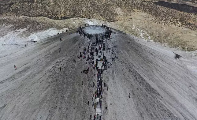 Hindu devotees climb stairs to reach on top of a mud volcano to start Hindu pilgrims religious' rituals for an annual festival in an ancient cave temple of Hinglaj Mata in Hinglaj in Lasbela district in Pakistan's southwestern Baluchistan province, Friday, April 26, 2024. More than 100,000 Hindus are expected to climb mud volcanoes and steep rocks in southwestern Pakistan as part of a three-day pilgrimage to one of the faith's holiest sites. (AP Photo/Mohammad Farooq)