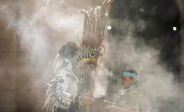 Mexica dancers burn incense during a ceremony commemorating the 503rd anniversary of the fall of the Aztec empire's capital, Tenochtitlan, in Mexico City, Tuesday, Aug. 13, 2024. (AP Photo/Eduardo Verdugo)