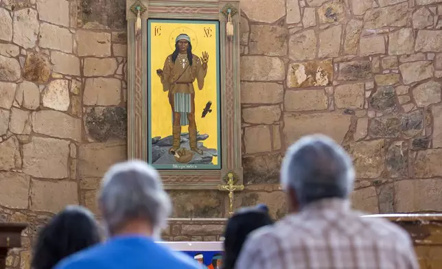 The Apache Christ painting hangs behind the altar of St. Joseph Apache Mission church in Mescalero, New Mexico, Saturday, July 13, 2024. The painting, an icon that depicts Christ as a Mescalero medicine man, was the forefront of a tension-filled episode between the community and the local Diocese when it was removed by the church's then priest when the region was reeling from wildfires. (AP Photo/Andres Leighton)