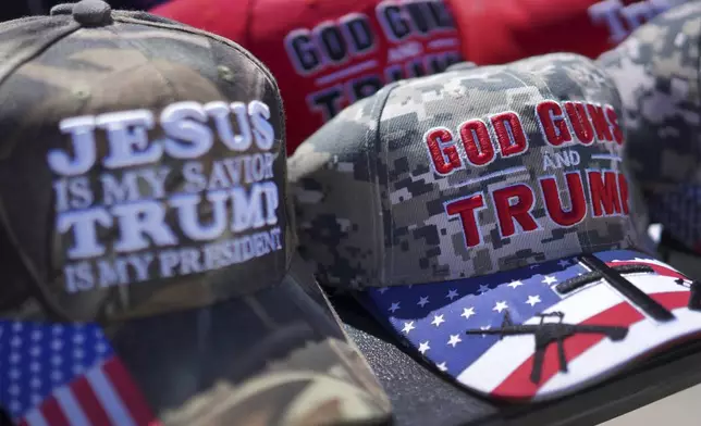 Hats reading, "God, Guns and Trump," and "Jesus is my savior, Trump is my president," are sold at a campaign rally for former president Donald Trump in Vandalia, Ohio, on Saturday, March 16, 2024. Trump, who is coasting into a third Republican presidential nomination, continues to draw strong support from evangelicals and other conservative Christians. (AP Photo/Jessie Wardarski)