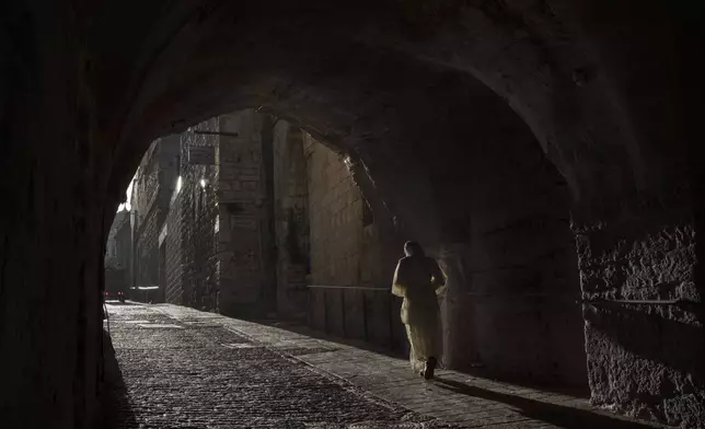 A woman walks down an alley in the Old City of Jerusalem, Sunday, March 10, 2024. Officials in Saudi Arabia have declared the start of the fasting month of Ramadan after sighting the crescent moon Sunday night. The announcement marks the beginning of Ramadan for many of the world's 1.8 billion Muslims. (AP Photo/Leo Correa)