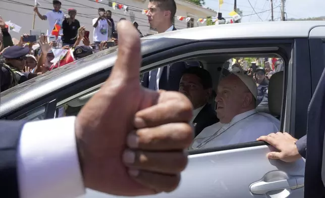 People greet Pope Francis as he travels in a car on way to another venue in Dili, East Timor, Tuesday, Sept. 10, 2024. (AP Photo/Firdia Lisnawati)