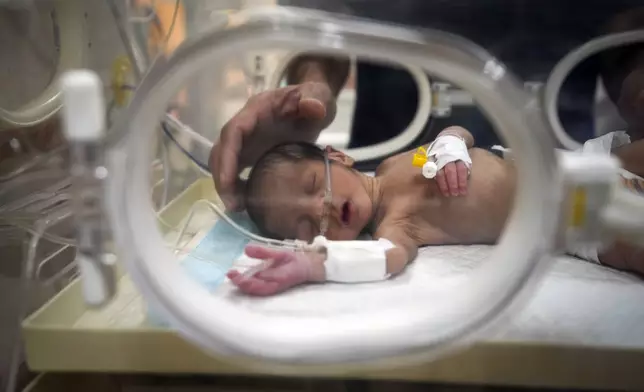 Ali al-Batran, a 20-day-old infant, lies in the intensive care unit with hypothermia at Al-Aqsa Martyrs Hospital in Deir al-Balah, central Gaza, Sunday, Dec. 29, 2024. His twin brother, Jomaa, has died, as local health officials report at least three other infant deaths from the cold in recent weeks. (AP Photo/Abdel Kareem Hana)