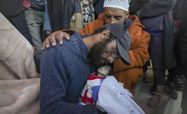 EDS NOTE: GRAPHIC CONTENT - Yehia al-Batran grieves as he holds the body of his 20-day-old son Jomaa, who died from hypothermia, at Al-Aqsa Martyrs Hospital in central Gaza, Sunday, Dec. 29, 2024. Jomaa's twin brother, Ali, remains in intensive care, as local health officials report at least three other infant deaths from the cold in recent weeks. (AP Photo/Abdel Kareem Hana)