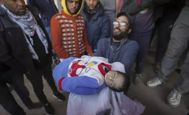 EDS NOTE: GRAPHIC CONTENT - Yehia al-Batran grieves as he holds the body of his 20-day-old son Jomaa, who died from hypothermia, at Al-Aqsa Martyrs Hospital in central Gaza, Sunday, Dec. 29, 2024. Jomaa's twin brother, Ali, remains in intensive care, as local health officials report at least three other infant deaths from the cold in recent weeks. (AP Photo/Abdel Kareem Hana)