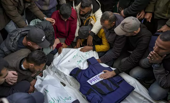 Relatives and friends mourn over the bodies of five Palestinian journalists who were killed by an Israeli airstrike in Gaza City at the Al-Aqsa Hospital in Deir al-Balah, Thursday, Dec. 26, 2024. (AP Photo/Abdel Kareem Hana)