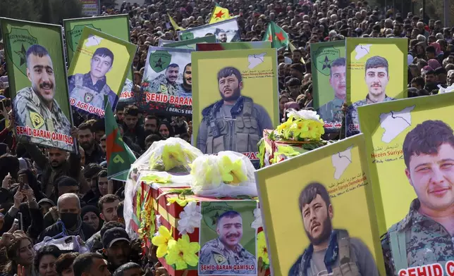 The coffins of two of six Kurdish fighters from the Syrian Democratic Forces (SDF) killed in ongoing clashes with Turkish-backed militias in northern Syria are carried during their funeral in Qamishli, northeastern Syria, Thursday, Dec. 26, 2024. (AP Photo/Hogir El Abdo)