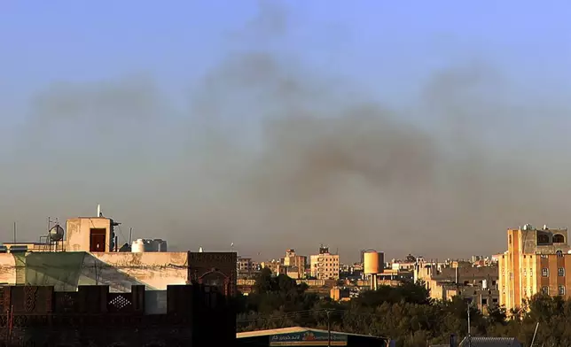 Smoke rises from the area around the International Airport following an airstrike, as seen from Sanaa, Yemen, Thursday, Dec. 26, 2024. The Israeli military reported targeting infrastructure used by the Houthis at the Sanaa International Airport, as well as ports in Hodeida, Al-Salif, and Ras Qantib, along with power stations.(AP Photo/Osamah Abdulrahman)