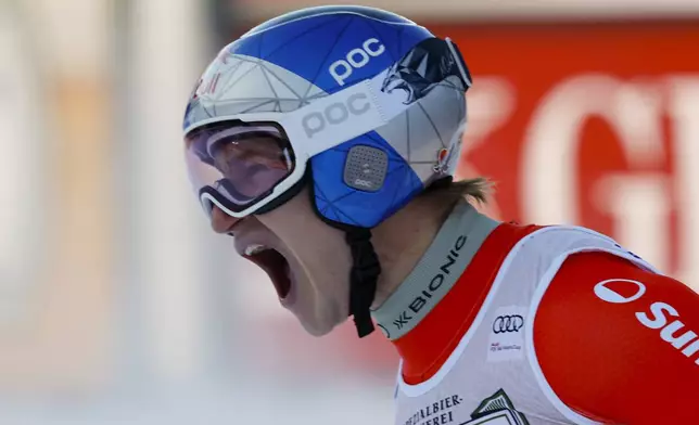 Switzerland's Marco Odermatt celebrates at the finish area of an alpine ski, men's World Cup downhill, in Val Gardena, Italy, Saturday, Dec. 21, 2024. (AP Photo/Alessandro Trovati)