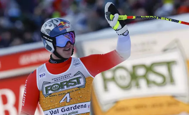 Switzerland's Franjo von Allmen celebrates at the finish area of an alpine ski, men's World Cup downhill, in Val Gardena, Italy, Saturday, Dec. 21, 2024. (AP Photo/Alessandro Trovati)