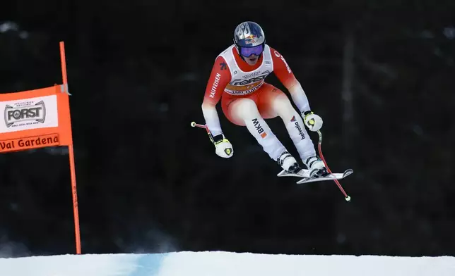 Switzerland's Franjo von Allmen speeds down the course during an alpine ski, men's World Cup downhill, in Val Gardena, Italy, Saturday, Dec. 21, 2024. (AP Photo/Gabriele Facciotti)