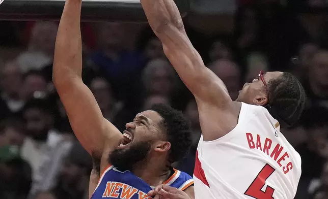 Toronto Raptors forward Scottie Barnes (4) fouls New York Knicks centre Karl-Anthony Towns (32) during the first half of an NBA basketball game in Toronto, Monday, Dec. 9, 2024. (Nathan Denette//The Canadian Press via AP)