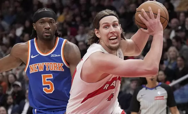 Toronto Raptors forward Kelly Olynyk (41) drives past New York Knicks forward Precious Achiuwa (5) during the first half of an NBA basketball game in Toronto, Monday, Dec. 9, 2024. (Nathan Denette//The Canadian Press via AP)