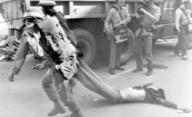 FILE- Soldiers carry away the body of a rebel killed in a firefight Tuesday May 27, 1980, when South Korean troops recaptured this riot-battered city of Gwangju (Kwangju). (AP Photo/File)
