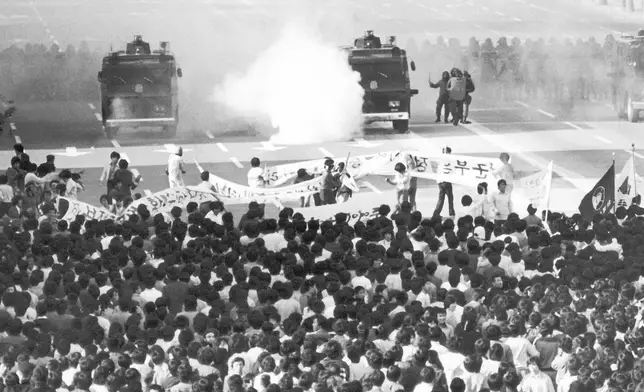 FILE- Police vehicle sprays tear gas at tens of thousands of student demonstrators in downtown Seoul, South Korea on Thursday, May 15, 1980. (AP Photo/Kim Chon-Kil, File)