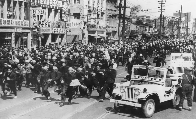 FILE- Students hurl rocks and shout slogans at the police in defiance of a government ban on demonstrations in South Korea, on Monday, April 18, 1960. (AP Photo/File)