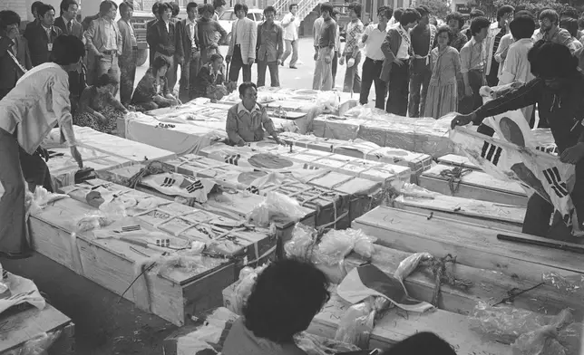 FILE- Families and relatives gather around the coffins of dead protesters at provincial headquarters in Gwangju (Kwangju), South Korea, May 23, 1980, some 250 kilometers south of Seoul, South Korea. (AP Photo/Kin Chon Kil, File)