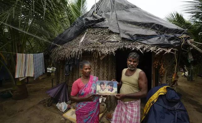 A. Subramaniyam, a fisherman, and his wife Gandhimathi holds a photograph of their children S. Sugan, 12, and S. Vinitha, 9, who perished in the tsunami 2004, at their home in Seruthur, Nagapattinam, India, Sunday, Dec. 15, 2024. (AP Photo/Mahesh Kumar A.)