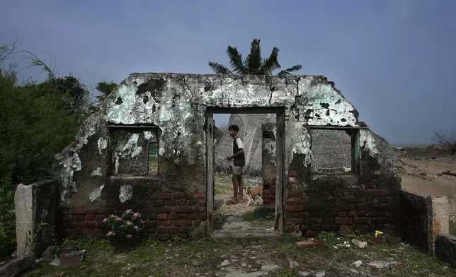 A boy walks through an abandoned and damaged house during the 2004 tsunami, in Nagapattinam, India, Monday, Dec.16, 2024. (AP Photo/Mahesh Kumar A.)