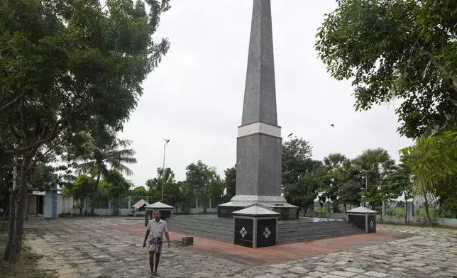 A man walks past a memorial tower built for the victims of the 2004 tsunami, where around 2,000 bodies were buried in Velankanni, Nagapattinam, India, Sunday, Dec. 15, 2024. (AP Photo/Mahesh Kumar A.)