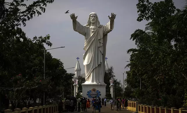 Devotees walk past a huge statue of Jesus Christ at the Basilica of Our Lady of Good Health shrine, where hundreds of visiting devotees died during 2004 Tsunami, in Velankanni, Nagapattinam, India, Sunday, Dec. 15, 2024. (AP Photo/Mahesh Kumar A.)