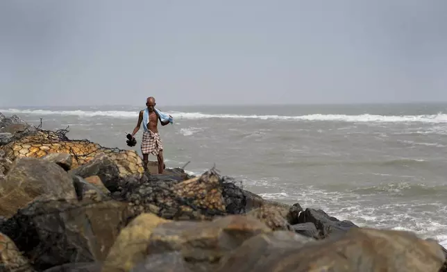 A person walks on the damaged embankment of 2004 tsunami in Nagapattinam, one of the severely damaged town during 2004 tsunami, India, Monday, Dec.16, 2024. (AP Photo/Mahesh Kumar A.)