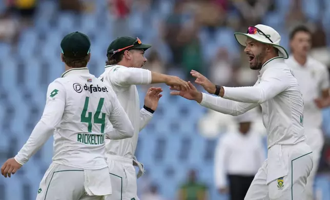 South Africa's Tristan Stubbs, centre, celebrates with his teammate Aiden Markam, right, after taking a catch to dismiss Pakistan's captain Shan Masood for 28 runs during day two of the Test cricket match between South Africa and Pakistan, at the Centurion Park in Centurion, South Africa, Friday, Dec. 27, 2024. (AP Photo/Themba Hadebe)