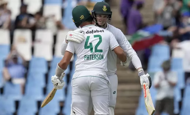 South Africa's Corbin Bosch, facing, is embraced by teammate Dane Paterson after scoring his debut half century during day two of the Test cricket match between South Africa and Pakistan, at the Centurion Park in Centurion, South Africa, Friday, Dec. 27, 2024. (AP Photo/Themba Hadebe)