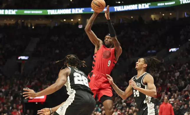 Portland Trail Blazers forward Jerami Grant (9) looks to pass the ball away from San Antonio Spurs center Charles Bassey (28) and guard Devin Vassell (24) during the first half of an NBA basketball game Friday, Dec. 13, 2024, in Portland, Ore. (AP Photo/Amanda Loman)