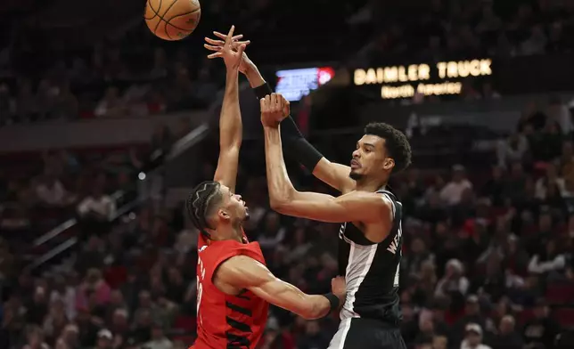 San Antonio Spurs center Victor Wembanyama (1) passes over Portland Trail Blazers forward Toumani Camara (33) during the first half of an NBA basketball game Friday, Dec. 13, 2024, in Portland, Ore. (AP Photo/Amanda Loman)