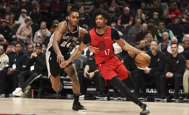 Portland Trail Blazers guard Shaedon Sharpe (17) drives to the basket as San Antonio Spurs guard Devin Vassell (24) defends during the first half of an NBA basketball game Friday, Dec. 13, 2024, in Portland, Ore. (AP Photo/Amanda Loman)