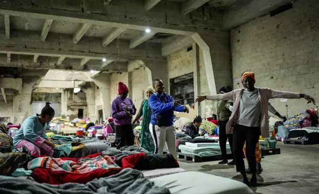 Sierra Leonean migrant workers stranded in Lebanon, dance as they wait to be repatriated back home, as they are sheltered at a former car dealership in Hazmieh, east of Beirut, Lebanon, Wednesday, Dec. 4, 2024. (AP Photo/Hassan Ammar)