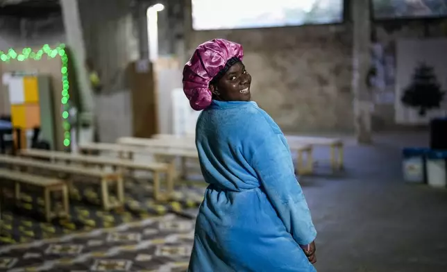 A Sierra Leonean migrant worker stranded in Lebanon, poses for a photograph as she waits to be repatriated back home, while sheltered at a former car dealership in Hazmieh, east of Beirut, Lebanon, Wednesday, Dec. 4, 2024. (AP Photo/Hassan Ammar)