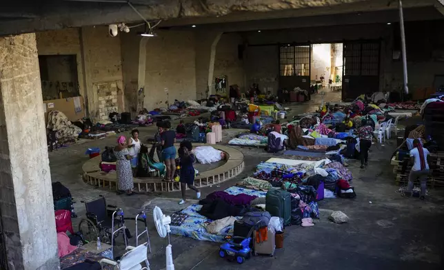 Female Sierra Leonean migrant workers stranded in Lebanon, wait to be repatriated back home, as they are sheltered at a former car dealership that was turned into a shelter in Hazmieh, east of Beirut, Lebanon, Friday, Nov. 15, 2024. (AP Photo/Hassan Ammar)