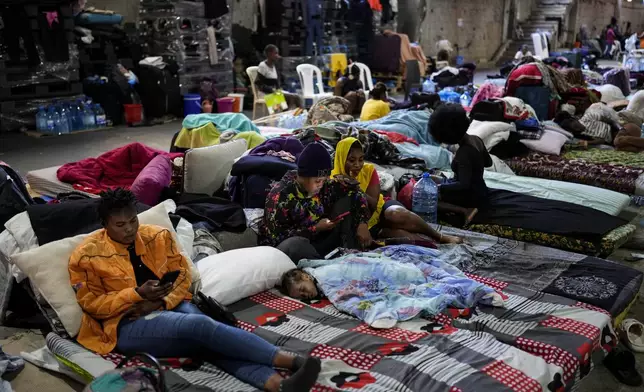 Female Sierra Leonean migrant workers stranded in Lebanon, wait to be repatriated back home, as they are sheltered at a former car dealership shop that was turned into a shelter in Hazmieh, east of Beirut, Lebanon, Friday, Nov. 15, 2024. (AP Photo/Hassan Ammar)