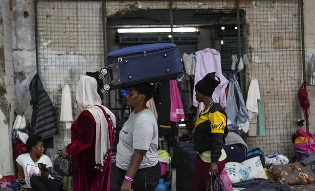 Female Sierra Leonean migrant workers stranded in Lebanon, wait to be repatriated back home, as they are sheltered at a former car dealership shop that was turned into a shelter in Hazmieh, east of Beirut, Lebanon, Friday, Nov. 15, 2024. (AP Photo/Hassan Ammar)