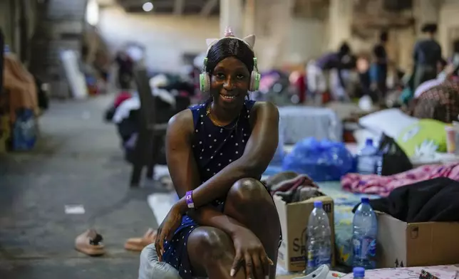 A Sierra Leonean migrant worker stranded in Lebanon, poses for a photograph as she waits to be repatriated back home, at a former car dealership that was turned into a shelter in Hazmieh, east of Beirut, Lebanon, Friday, Nov. 15, 2024. (AP Photo/Hassan Ammar)