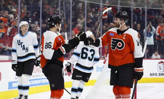 Philadelphia Flyers' Joel Farabee (86) celebrates after his goal with Sean Couturier, right, during the second period of an NHL hockey game against the Utah Hockey Club, Sunday, Dec. 8, 2024, in Philadelphia. (AP Photo/Derik Hamilton)