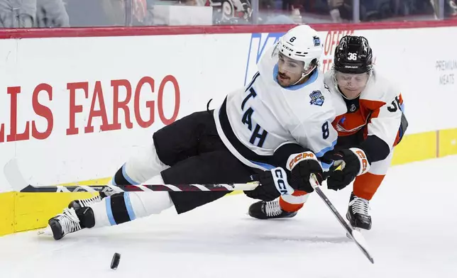 Utah Hockey Club's Nick Schmaltz, left, and Philadelphia Flyers' Emil Andrae, right, race for the puck during the first period of an NHL hockey game, Sunday, Dec. 8, 2024, in Philadelphia. (AP Photo/Derik Hamilton)