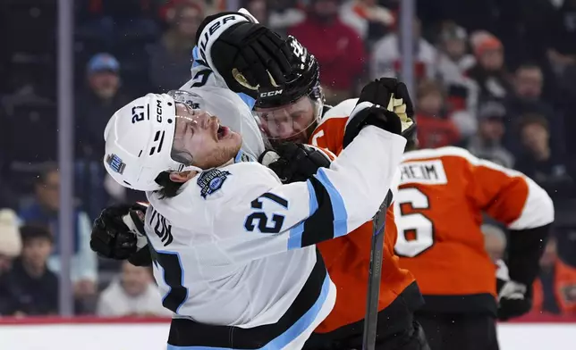 Utah Hockey Club's Barrett Hayton (27) is shoved by Philadelphia Flyers' Sean Couturier, center right, after a play during the first period of an NHL hockey game, Sunday, Dec. 8, 2024, in Philadelphia. (AP Photo/Derik Hamilton)
