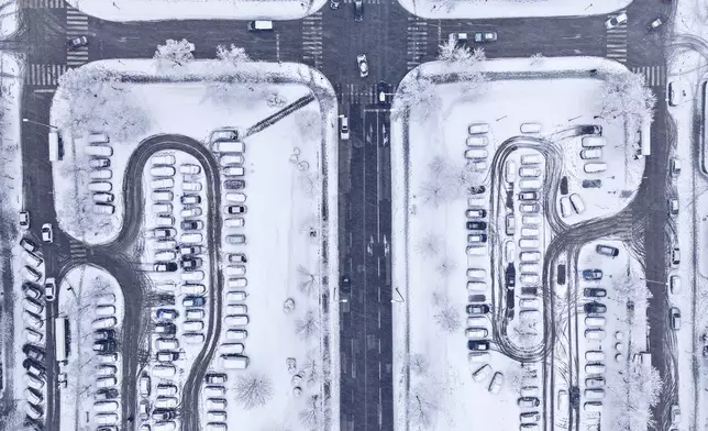 An aerial view of traffic and parked cars during heavy snowfall in Alipasino Polje neighborhood of Sarajevo, Bosnia, Monday, Dec. 23, 2024. (AP Photo/Armin Durgut)